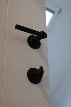 Modern black door handle and matching lock on white door
