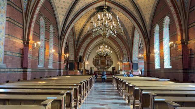 Vaulted brick nave and chandeliers inside a Swedish church