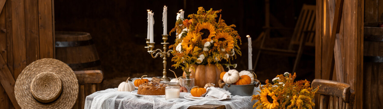 Banner. Beautiful fancy fall wedding table decor, countryside style cottage core. Wooden furniture, candlelight, centrepiece, natural sunflowers. Cozy atmosphere, autumn vibes, stylish house decor