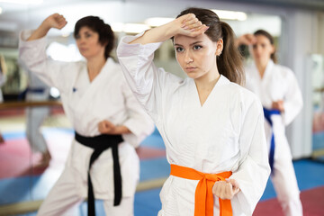 Kata karate female classes movements , fighting techniques to prepare them for competitions. Oriental martial arts, training and obtaining black belt. Sport in everyday life of city dweller.. © JackF