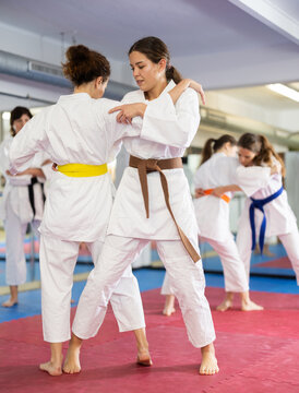 Women students athletes at Academy of martial Arts practice karate and fight opponents in pairs. Obtaining black belt, advanced training, highest dan of martial arts. Sport to max. .