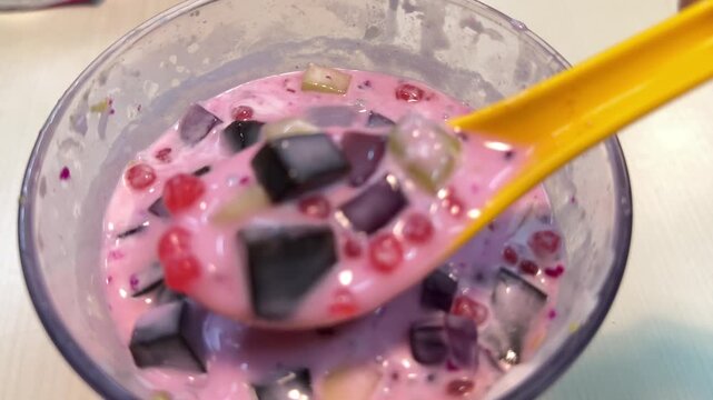 Es campur mixed ice jelly dessert, scooping pouring pink milky sweet drink, slow motion 4K horizontal video