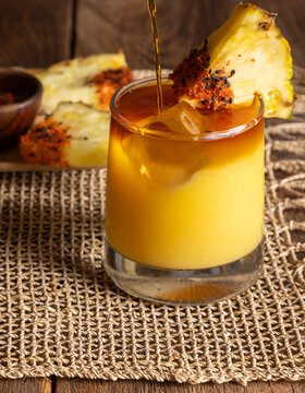 Layered cocktail with pineapple spice garnish