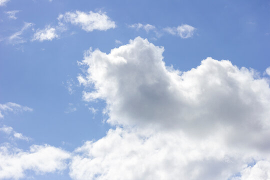 Fluffy white cumulus clouds floating in a bright blue sky