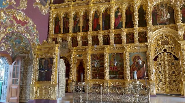 Ornate golden iconostasis with beautiful holy icons stands inside St Sergius Church at Trinity Lavra of St Sergius in Sergiyev Posad. Historical russian orthodox cathedral interior, religious landmark