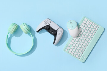 Gaming and digital entertainment, video game controller with computer keyboard and headphones on a blue background for leisure and technology lifestyle © Pixel-Shot