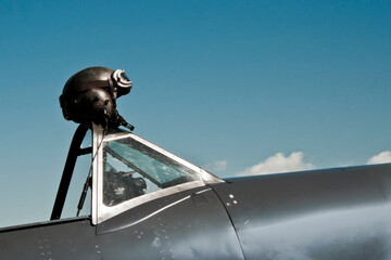 Flight helmet resting on a vintage aircraft canopy © Marisa