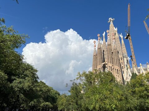Barcelona. Vista de la Sagrada Familia de Antoni Gaud&iacute; en d&iacute;a soleado con cielo azul y gran nube de algod&oacute;n o c&uacute;mulo por detr&aacute;s.
