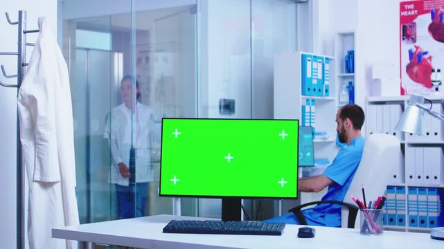 Doctor arriving in clinic behind green screen monitor