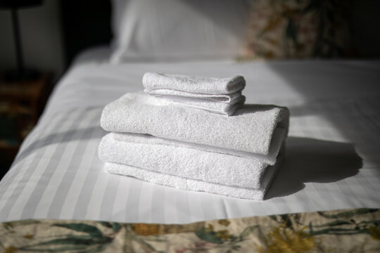 Stacked White Towels Cozy Hotel Bed