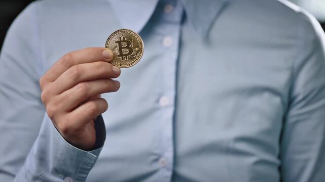 Close-Up of Person Holding Physical Bitcoin Coin and Fan of One Hundred US Dollar Bills, Concept of Cryptocurrency vs Traditional Fiat Currency and Financial Investment