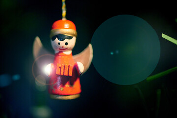 Fototapeta premium Angel, decoration and closeup on Christmas tree, home and light for festive holiday event with flare. Doll, bokeh or hanging ornament for xmas season, tradition and interior for celebration at house