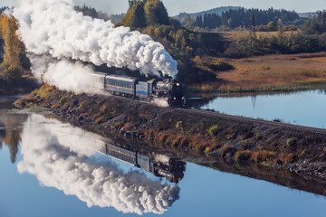 Retro steam train moves along the lake. © serjiob74