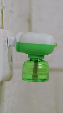 Vertical: Plugging an electric mosquito repellent into power strip. Using an electric mosquito repellent.