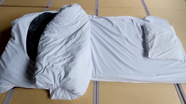 和室の畳の上に敷かれた一組の白い布団（合宿所・民宿・寝具）