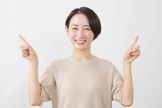 両手で左右を指し示す女性　白背景