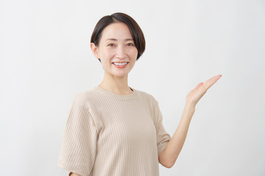 手のひらで指し示し案内する女性　白背景