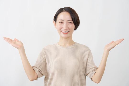 手のひらで指し示す笑顔の女性　白背景