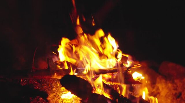 Bonfire night at starry campsite. Camping bonfire. Burning flames. Burning fire for barbecue. Bonfire for BBQ. Campfire fire at night. Cozy campfire in camp. Glowing campfire. Camping lifestyle