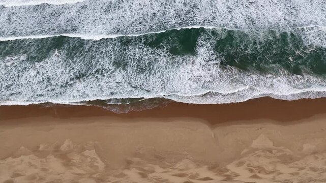 Victoria Coastline, Australia &ndash; 4K aerial drone view of 4K aerial top-down drone view of powerful ocean waves, white sea foam and turquoise water washing onto golden sandy beach
