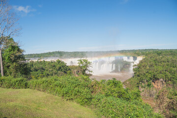 Panoramic view of Iguazu Falls with a beautiful rainbow over the cascades in South America © GraysonStock