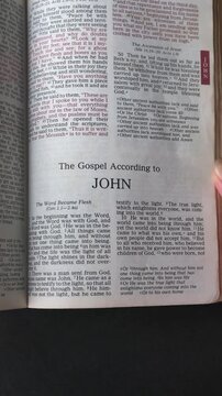 Opening to the book of John of the New Testament in the Holy Bible. New Revised Standard Version. Vertical video.