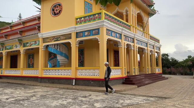 Young man walking around Cao Dai Temple of Da Lat, Dalat, Lam Dong, Vietnam.
