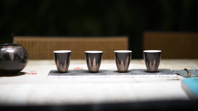 metal tea set and cups arranged on table surface