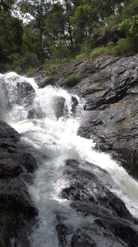 Close view of Datanla Waterfall cascading over rocks near Da Lat, Vietnam, vertical video