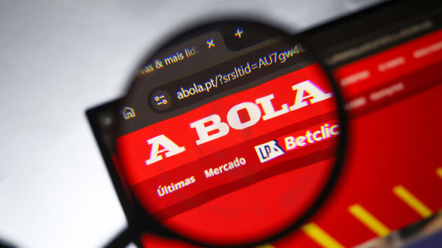A bola sports website logo seen through magnifying glass red header background for football news digital media coverage.
