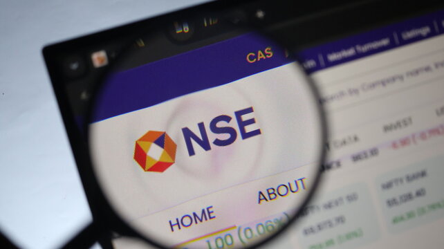 National stock exchange logo viewed through handheld magnifying glass highlighting website design for financial research.