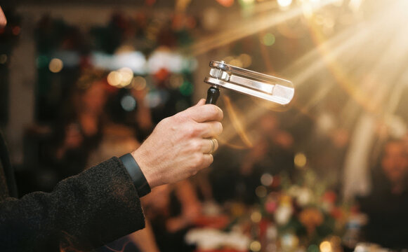 Person holding a traditional wooden gragger noise maker during a festive celebration event