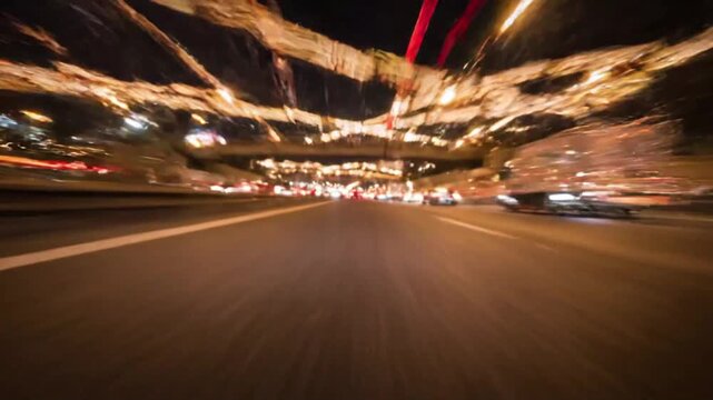 Night time-lapse of driving on a busy city highway with motion blur light trails