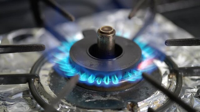 点火されたガスコンロの青い炎のクローズアップ（キッチン・生活感・調理）