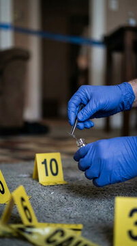 Crime Scene Investigation Forensics Officer Collecting Evidence with Gloves and Tweezers Yellow Markers