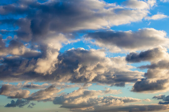 Clouds at sunset. Atmosphere, weather conditions. Fluffy cloud on blue sky background. Sunny summer sky. No people, nobody.