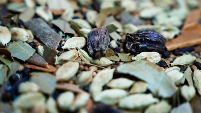 Close-up of dried cardamom pods and natural spices, Close-up of dried cardamom pods and natural spices scattered across a textured surface, with earthy colors and shallow focus