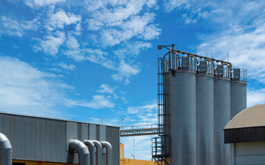 Industrial storage silos at agricultural feed mill factory, used for bulk grain handling, raw material storage and animal feed production for modern livestock farming. Agribusiness infrastructure. © Fahroni