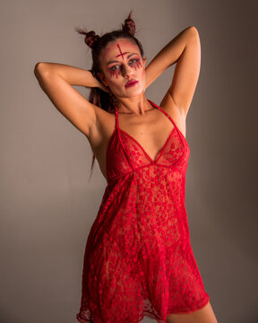 Woman posing as devil with inverted cross makeup