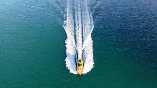 Pilot boat at sea. Motorboat sailing at sea. Motorboat aerial top view. Pilot boat motor yacht at sea. Pilot boat with trail on water. Maritime lifestyle concept. Fast motorboat ride