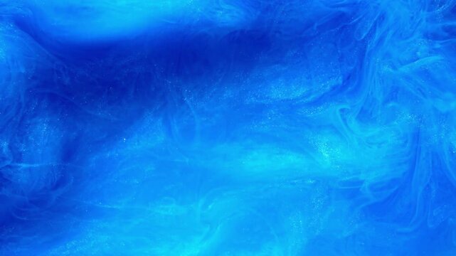 Swirling blue pigment powder clouds evoke luminous, dreamy azure depths. Perfect for backgrounds, design elements, and artistic projects.