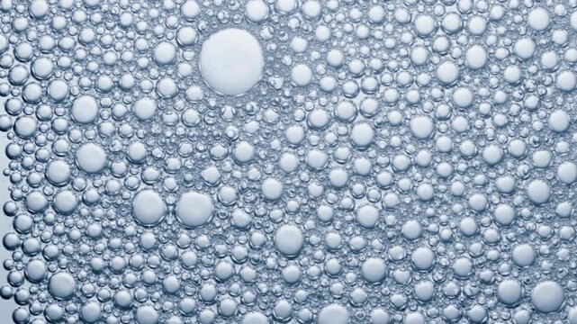 Cluster of transparent liquid spheres form dense soap foam texture, perfect for backgrounds or sciencerelated designs. Backgrounds, science designs, soap texture, transparent spheres, liquid bubbles, 