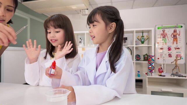 Two Schoolgirls in Lab Coats Conducting Science Experiments in Classroom