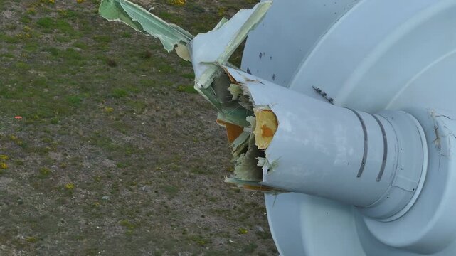 Aerial inspection showing a catastrophic failure of a wind turbine. The blade root is broken, revealing internal composite materials