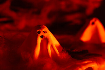 Atmospheric Halloween concept designed for seasonal greetings announcements or promotional messages combining handmade clay ghosts with classic spooky decorations to symbolize mystery, celebration © anna.stasiia