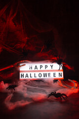 Atmospheric Halloween concept designed for seasonal greetings announcements or promotional messages combining illuminated typography HAPPY HALLOWEEN with classic spooky decorations to symbolize © anna.stasiia