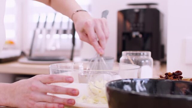Pastry preparation. Mixing process. Female chef hand whisking butter sugar ingredients for homemade dough in glass bowl countertop.