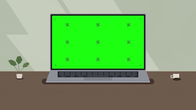 pixel art laptop with green screen animation on wooden desk