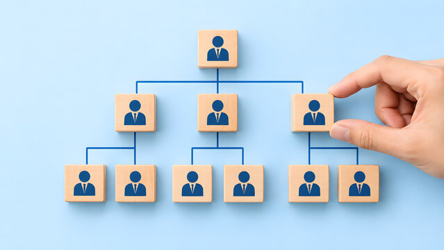Hand placing wooden block on organizational chart on blue background