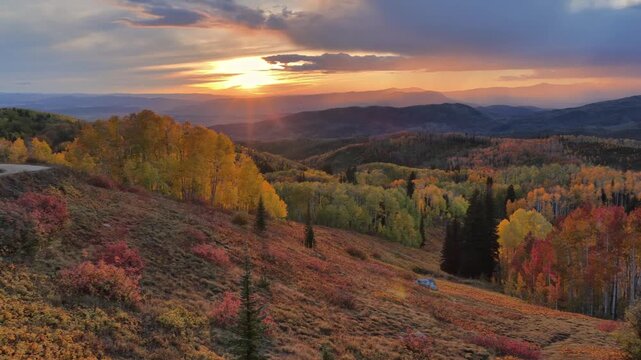 Beautiful drone view over autumn aspen trees and mountains in Colorado at sunset